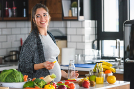 Embarazada en la cocina con alimentos saludables